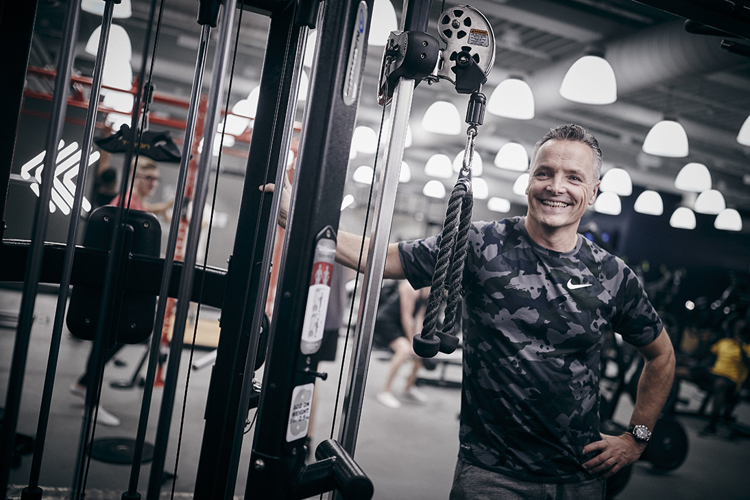 Man tränar med styrkemaskin på gym